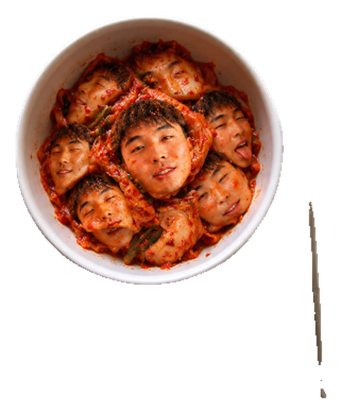 Kimchu: a white bowl of kimchi with six smiling faces tucked among the cabbage leaves, a steel chopstick beside it